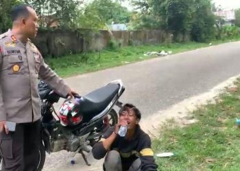 AKBP Guntur Saputro memberikan minum kepada pebalap liar, karena kelelahan berlari saat melihat polisi datang ke lokasi balal liar. (Dok istimewa)