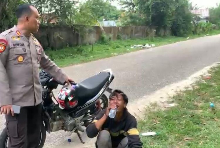 AKBP Guntur Saputro memberikan minum kepada pebalap liar, karena kelelahan berlari saat melihat polisi datang ke lokasi balal liar. (Dok istimewa)