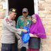 Kasi Humas Polres Muarojambi AKP Armadi saat menyerahkan paket Sembako kepada salah satu warga penerima. [Dok Humas Polres Muarojambi]