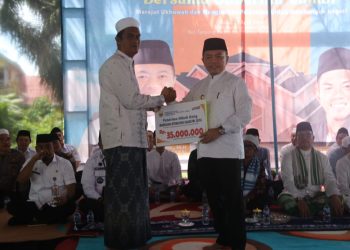 Gubernur Al Haris saat menyerahkan secara simbolis  kepada perwakilan Madrasah Ibtidaiyah Sabatul Ulta dalam acara silaturahmi bersama tokoh agama dan masyarakat di Tanjung Raden, Kota Jambi, Rabu (23/4/2025). (dok. Erik Kominfo)