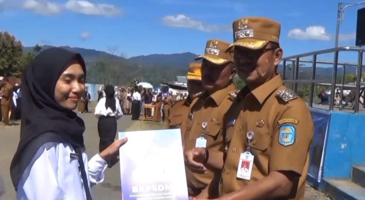 Bupati Kerinci Monadi (kanan) menyerahkan SK CPNS kepada salah satu peserta penerima di Lapangan Perkantoran Bukit Tengah, Siulak, Senin (19/5). (Dok .Yol)