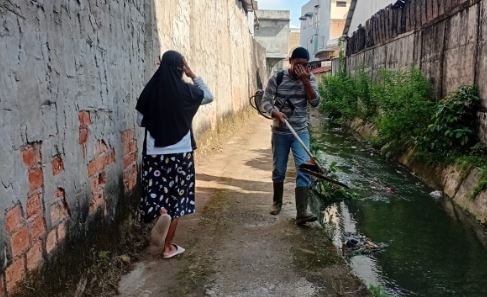 Warga RT 09 Sulanjana sedang membersihkan saluran drainase dalam kegiatan gotong royong serentak, Minggu (15/6/2025). (Dok. Nahar)