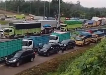 Kemacetan panjang kendaraan berat dan pribadi mengular di ruas Jalan Lintas Timur KM 14 Jambi, Selasa (18/6/2025), akibat proyek perbaikan jalan dan intensitas hujan tinggi. (Foto: Nahar)