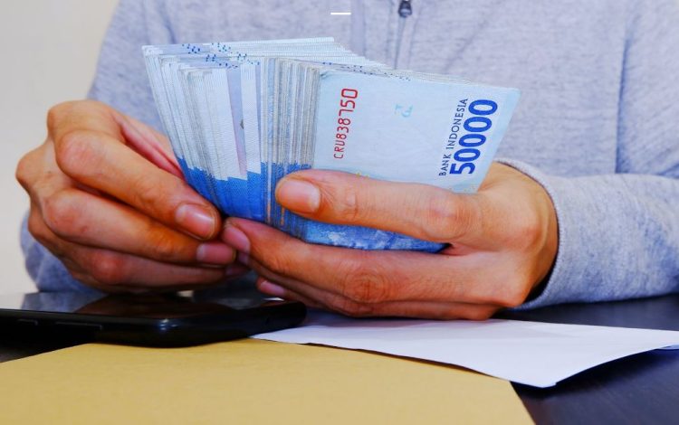 Ilustarasi Seorang pegawai menghitung lembaran uang pecahan Rp50.000 (Dok .kemenkeu.go.id)