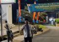Seorang warga RT 11 Kelurahan Pasir Putih berpose di depan gerbang Masjid Ummu 'Aisyah, lokasi peringatan Tahun Baru Islam 1 Muharram 1447 H yang diisi pawai obor dan tausiyah, Kamis (26/6/2025) malam. (Dok. Yola)