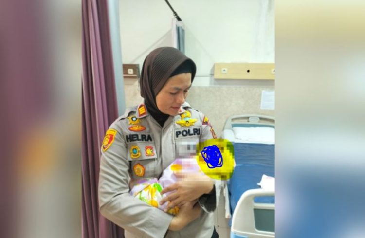Kapolsek Jambi Selatan AKP Helrawati menggendong bayi perempuan yang ditemukan di bawah jendela Panti Sosial Harapan Mulya, Kamis (5/6/2025). (Dok Stepanus)