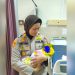Kapolsek Jambi Selatan AKP Helrawati menggendong bayi perempuan yang ditemukan di bawah jendela Panti Sosial Harapan Mulya, Kamis (5/6/2025). (Dok Stepanus)