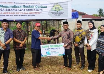 Dirut Perumdam Tirta Mayang, Dwike Riantara (kanan), secara simbolis menyerahkan hewan kurban kepada panitia pelaksana di lingkungan warga RT 27 Kota Jambi, Kamis (5/6/2025). (Dok. Yola)