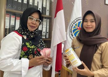Arumingtyas Khoni Dahlia (kanan), siswi SMAN 3 Kota Jambi yang juga atlet karate, menyerahkan tabungan hasil prestasinya untuk berkurban didampingi gurunya, Kamis (5/6/2025). (Dok. Yola)