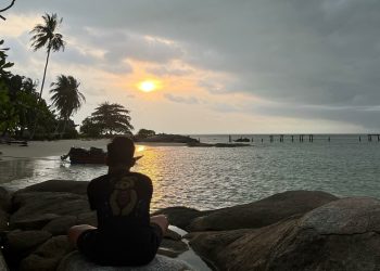 Surya duduk tenang di atas batu pesisir Pulau Berhala, menikmati senja yang perlahan tenggelam, Sabtu (31/05/2025).(Foto: Surya Paramata)
