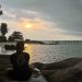 Surya duduk tenang di atas batu pesisir Pulau Berhala, menikmati senja yang perlahan tenggelam, Sabtu (31/05/2025).(Foto: Surya Paramata)