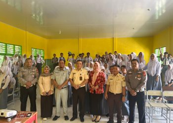 Petugas Jasa Raharja Samsat Muara Tebo, Kepolisian, dan Kepala Samsat Tebo berfoto bersama guru serta siswa-siswi SMKN 8 Tebo usai menggelar sosialisasi keselamatan lalu lintas dan edukasi administrasi kendaraan bermotor, Senin (16/6/2025). (Dok. Humas JR Jambi)