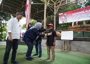 Seorang peserta School Camp 2025 menerima pin duta budaya dari perwakilan AHM dalam rangkaian kegiatan pelestarian angklung di Saung Angklung Udjo, Bandung, Jumat (21/6/2025). (Dok. Sisnen)