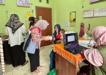Petugas kesehatan melakukan pencatatan dan pemeriksaan gizi balita dan ibu hamil dalam program penanggulangan stunting di Puskesmas Muara Kumpeh, Kabupaten Muaro Jambi, Kamis (24/7/2025). (Dok. Humas)