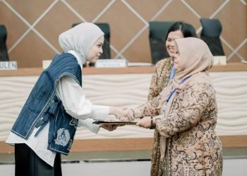 Marsha Lystia (kiri) bersalaman dengan Ketua GOW demisioner Dr. dr. Hj. Nadiyah Maulana, Sp.OG., usai terpilih secara aklamasi sebagai Ketua GOW Kota Jambi periode 2025–2030 dalam Musdalub yang digelar di Aula PKK Kota Jambi, Senin (14/7/2025). (Dok. Yola)