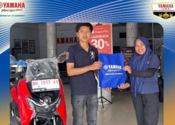 Seorang konsumen menerima hadiah eksklusif berupa merchandise dari perwakilan Yamaha Jambi dalam rangka perayaan HUT ke-51 Yamaha Indonesia. (dok. Yamaha Jambi)