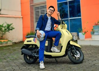 Elvaro, pengguna Yamaha Fazzio, berpose dengan motor andalannya yang berwarna kuning cerah di halaman kampus di Kota Jambi, Rabu (24/7/2025). (Dok.Yamaha)