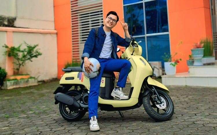 Elvaro, pengguna Yamaha Fazzio, berpose dengan motor andalannya yang berwarna kuning cerah di halaman kampus di Kota Jambi, Rabu (24/7/2025). (Dok.Yamaha)