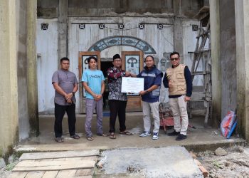 Manager Keuangan Pelindo Jambi, Rizki Nopriza, menyerahkan bantuan senilai Rp100 juta kepada Ketua Pengurus Masjid Al‑Munawarah, Supriyanto, didampingi pengurus masjid dan tim Pelindo Jambi di Muara Sabak Timur, Kabupaten Tanjung Jabung Timur, Senin (21/7/2025). (Dok. Pelindo)