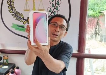 Ketua Umum LPKNI, Kurniadi Hidayat, menunjukkan produk ponsel yang dipesan melalui siaran langsung di TikTok, namun tidak sesuai dengan yang dijanjikan. Barang yang diterima tanpa merek dan tanpa legalitas resmi. (Dok. Stepanus)