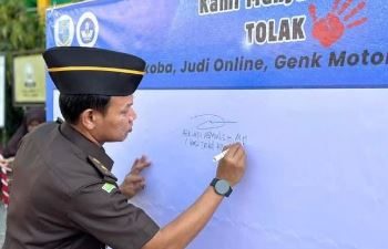 Perwakilan Kejaksaan Negeri Jambi menandatangani dukungan gerakan antinarkoba, antijudi daring, dan geng motor dalam kegiatan "Gerakan Pramuka Goes to School" di SMPN 11 Kota Jambi, Senin (21/7/2025). (Dok, Daus)