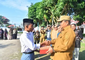 Andi, seorang siswa Sekolah Rakyat menerima bantuan sepatu sekolah gratis dari Wali Kota Jambi, Maulana, di Kecamatan Jambi Selatan, Selasa (26/8/2025). (Dok.Yola)