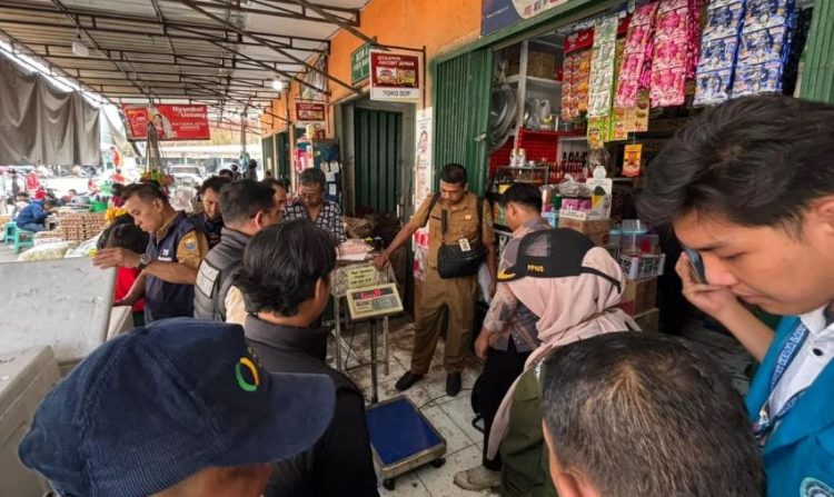 Petugas gabungan dari Satgas Pangan Provinsi Jambi dan Ditreskrimsus Polda Jambi memeriksa alat timbang dan barang dagangan di salah satu toko grosir di Pasar Angso Duo, Jambi, saat inspeksi mendadak terkait dugaan peredaran beras oplosan, Rabu (17/7/2025). (Dok. Daus)