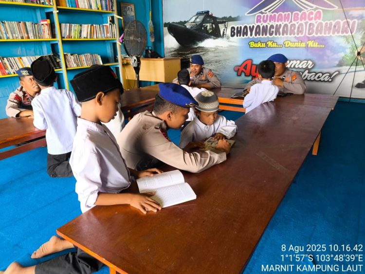 Personel Ditpolairud Polda Jambi memberikan motivasi gemar membaca kepada siswa SDN 30 Kuala Jambi di Rumah Baca Bhayangkara Bahari, Jumat (8/8/2025) (dok.Humas)