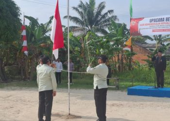 Petugas mengibarkan bendera Merah Putih pada upacara peringatan HUT ke-80 RI di Perumnas Aurduri Blok C, Kelurahan Aurkenali, Kecamatan Telanaipura, Kota Jambi, Minggu (17/8/2025). (Dok.Stepanus)