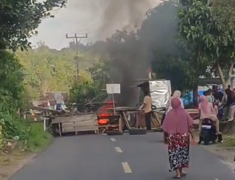 Warga memblokir jalan nasional Kerinci–Bangko di Desa Pulau Pandan, Kabupaten Kerinci, dengan membakar ban dan memasang barikade kayu, Jumat (22/8/2025). (Dok. Warga)