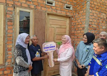Ketua Pembina Posyandu Provinsi Jambi, Hesti Haris, menyerahkan kunci simbolis program Bedah Rumah kepada warga penerima manfaat di Desa Pematang Gajah, Jaluko, Muaro Jambi, Jumat (29/8/2025).(Dok.Daus)