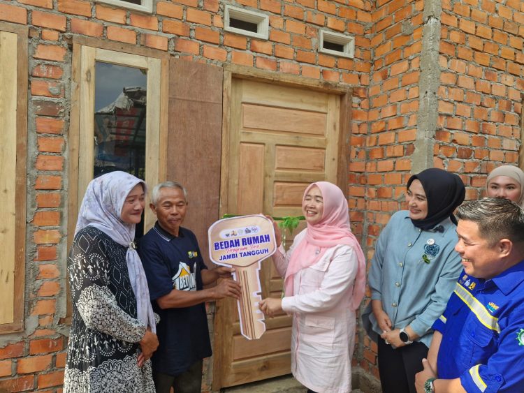 Ketua Pembina Posyandu Provinsi Jambi, Hesti Haris, menyerahkan kunci simbolis program Bedah Rumah kepada warga penerima manfaat di Desa Pematang Gajah, Jaluko, Muaro Jambi, Jumat (29/8/2025).(Dok.Daus)