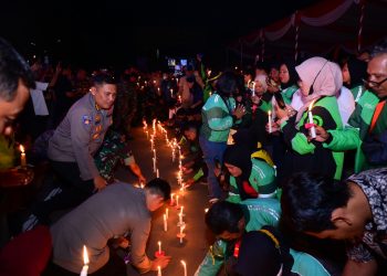 Kapolda Jambi Irjen Pol Krisno H. Siregar bersama komunitas ojek online dan masyarakat menyalakan lilin dalam doa bersama dan aksi damai 1.000 lilin di Mapolda Jambi, Minggu (31/8/2025) malam. (Dok.Nahar)