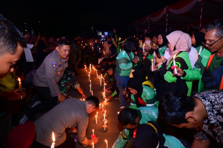 Kapolda Jambi Irjen Pol Krisno H. Siregar bersama komunitas ojek online dan masyarakat menyalakan lilin dalam doa bersama dan aksi damai 1.000 lilin di Mapolda Jambi, Minggu (31/8/2025) malam. (Dok.Nahar)