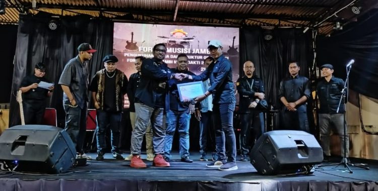 Serah terima kepemimpinan Forum Musisi Jambi dari Veruskhan kepada Mukhlis pada acara pengukuhan disalah satu kafe yang berada di kawasan mayang, Kota Jambi, Selasa (12/08/2025). (Dok.Stepanus) 