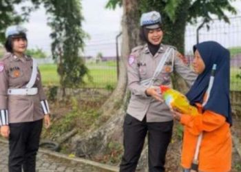 Anggota Satlantas Polresta Jambi menyerahkan bantuan sembako kepada petugas kebersihan dalam kegiatan Jumat Berkah di kawasan Thehok, Kota Jambi, Jumat (22/8/2025).(dok. Nahar)