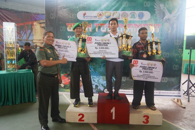 Danrem 042/Gapu Brigjen TNI Heri Purwanto (kiri) menyerahkan hadiah kepada juara umum Pencak Silat Kelas Prestasi pada penutupan Open Turnamen Piala Danrem 042/Gapu HUT ke-80 RI di Lapangan Tenis Indoor Korem 042/Gapu, Jambi, Rabu (13/8/2025). (Dok,. Nahar)