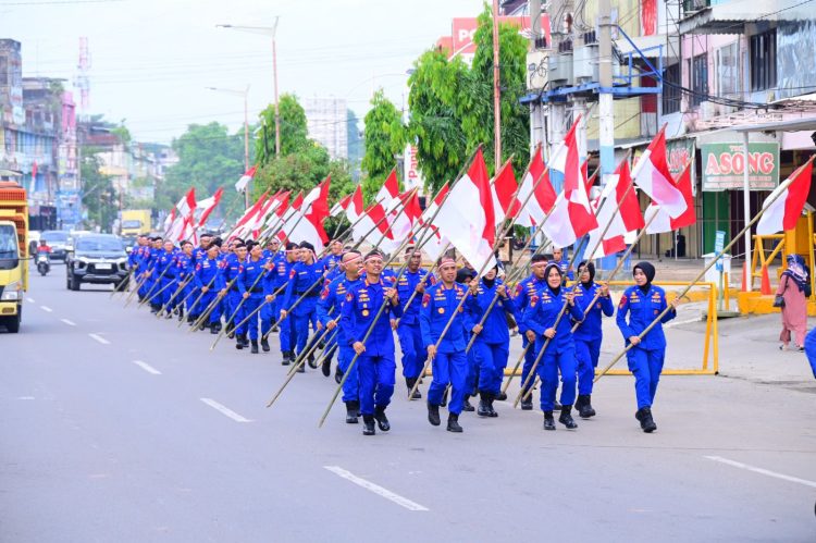 Personel Ditpolairud Polda Jambi melaksanakan pawai bendera merah putih di Kota Jambi dalam rangka memperingati HUT ke-80 Kemerdekaan RI, Rabu (20/8/2025). (Dok. Nahar)