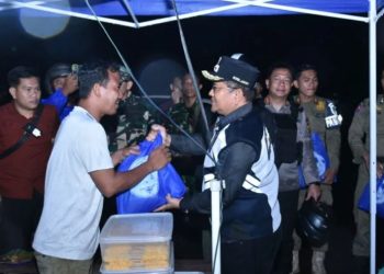 Wali Kota Jambi Maulana berbincang dengan pedagang sambil menyerahkan bantuan sembako saat patroli malam, Selasa (2/9/2025). (Dok. Daus)