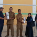 Kasubag TJSL PTPN IV Regional 4, Sumarfin Purba (kiri), menyerahkan bantuan sarana olahraga kepada Kepala Desa Pinang Tinggi, Edi Sudarmanto, di Aula Desa Pinang Tinggi, Muaro Jambi, Kamis (11/9/2025)( Dok. Stepanus)