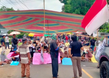 Warga bersama Barisan Perjuangan Rakyat (BPR) dan WALHI Jambi menggelar aksi duduk dan memblokir jalan nasional di depan Kantor BWSS Jambi, Sabtu (13/9/2025), menolak pembangunan stockpile batubara di kawasan pemukiman. (Dok. Stepanus)