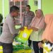 Kapolsek Rimbo Ilir IPTU Sarif Hidayatullah menyerahkan beras SPHP kepada warga dalam kegiatan Gerakan Pangan Murah di Kantor Desa Pulung Rejo, Kecamatan Rimbo Ilir, Senin (8/9/2025). (Dok. Humas)