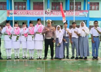 Kasat Lantas Polresta Jambi AKP Hadi Siswanto bersama siswa SMA Negeri 13 Kota Jambi dan personel kepolisian usai pelaksanaan program Police Go To School di halaman sekolah, Senin (8/9/2025). (Dok,. Nahar)
