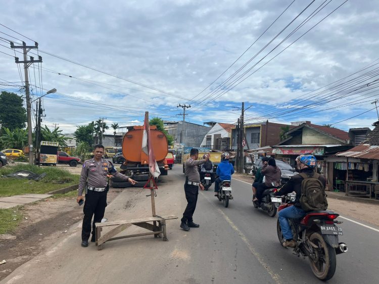 Personel Satlantas Polresta Jambi membagikan segitiga pengaman kepada sopir truk di Jalan Lingkar Kota Jambi, Selasa (2/9/2025) (Dok. Nahar)