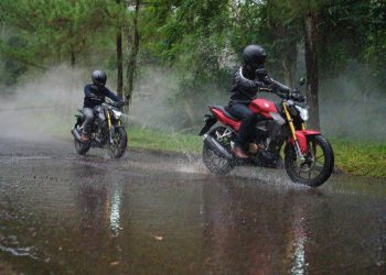 Ilustasri Pengendara sepeda motor melintas di jalanan yang tergenang air saat hujan deras (Dok. Sinsen)