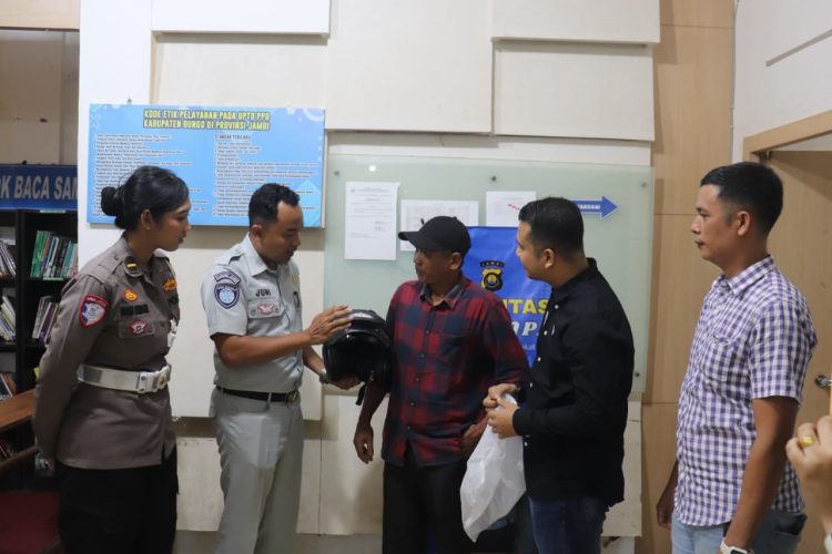 Petugas Jasa Raharja bersama Satlantas Polri menyerahkan helm berstandar SNI kepada wajib pajak di Samsat Muara Bungo dalam rangka peringatan Hari Keselamatan Transportasi, Jumat (19/9/2025). (Dok. Stepanus)