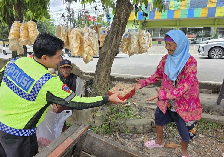 Petugas Satlantas Polresta Jambi membagikan nasi kotak kepada warga kurang mampu di kawasan Kota Jambi dalam kegiatan Jumat Berkah, Jumat (19/9/2025). (Dok. Nahar)