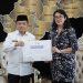 Gubernur Jambi Al Haris bersama Kepala Kanreg VII BKN Palembang Heni Sri Wahyuni menunjukkan nota kesepahaman penguatan sistem merit dan manajemen talenta ASN usai penandatanganan di Rumah Dinas Gubernur Jambi, Rabu (24/9/2025). (Dok. Daus)