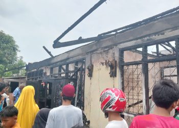 Warga berupaya membantu membersihkan puing-puing kebakaran yang menghanguskan satu rumah beserta tiga bedeng di RT 09 Kelurahan Solok Sipin, Kota Jambi, Selasa (27/9/2025). (Dok. Rio)