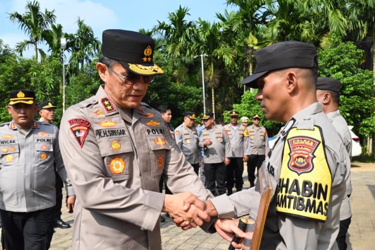 Kapolda Jambi Irjen Pol Krisno H. Siregar menyalami salah satu personel Bhabinkamtibmas penerima penghargaan pada apel penyerahan penghargaan dan sarana pelayanan di Polsek Sabak Barat, Kabupaten Tanjung Jabung Timur, Sabtu (27/9/2025). (Dok. Nahar)